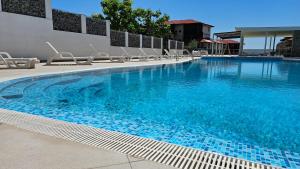 uma grande piscina com cadeiras e água azul em HoliVibes - sea view - Bulgaria em Sveti Vlas