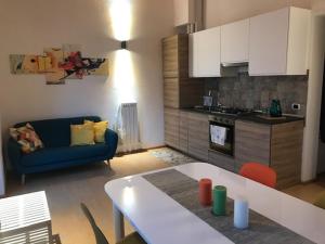 a living room with a blue couch and a kitchen at APPARTAMENTO RIO ACQUICCIOLA in Fiumalbo
