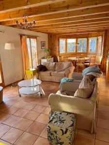 ein Wohnzimmer mit Sofas und einem Tisch in der Unterkunft Chalet Stickie by Swiss Alps Village in Hérémence
