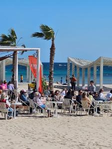 a group of people sitting in chairs on the beach at PLAYA POSTIGUET in Alicante