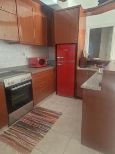 a kitchen with a red refrigerator and wooden cabinets at Maria's Apartments in Pigi