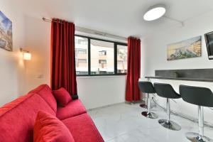 - un salon avec un canapé rouge et une table dans l'établissement Le Coquillage - 200 mètres de la Plage, à Cannes