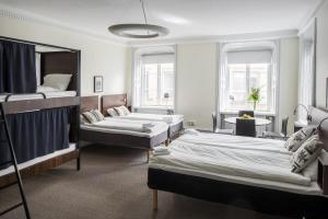 a room with two beds and a table and a room with at Castle House Inn in Stockholm
