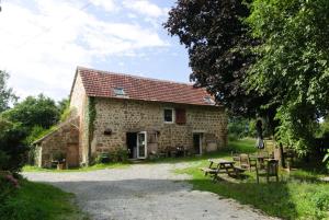 uma casa de pedra com uma mesa de piquenique e um banco de piquenique em KERFLAVEUR em La Fresnaye-au-Sauvage