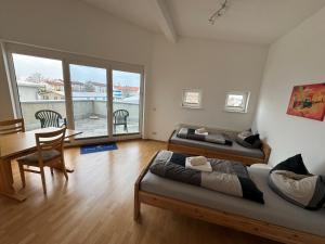 um quarto com 2 camas, uma mesa e cadeiras em Pension Schweizer em Laupheim
