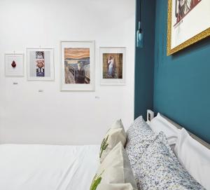 - une chambre avec des photos sur le mur dans l'établissement Napulitano Assaje Home, à Naples