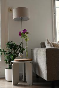 a living room with a table with a lamp and flowers at Quiet and spacious holiday home in Voorthuizen