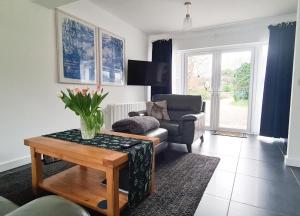 a living room with a vase of flowers on a table at Nara Seaside Retreat in Holywood