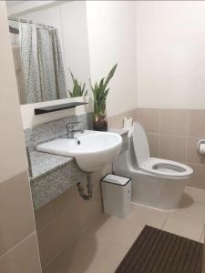 a bathroom with a sink and a toilet and a mirror at Fia Horizons @ Infina South Tower in Manila