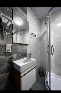 La salle de bains blanche est pourvue d'un lavabo et d'une douche. dans l'établissement Бутик-отель CHORBOG, à Samarcande