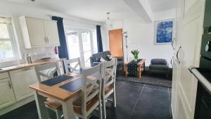 a kitchen and living room with a table and chairs at Nara Seaside Retreat in Holywood