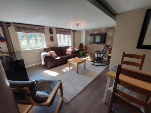 a living room with a couch and a table at Ex showhome in Old Brewery with pool in Oakhill