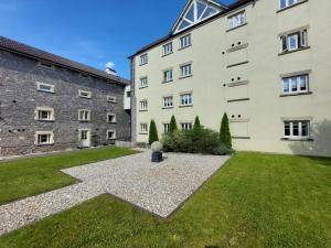 uma vista para o exterior de um grande edifício com um pátio em Ex showhome in Old Brewery with pool em Oakhill