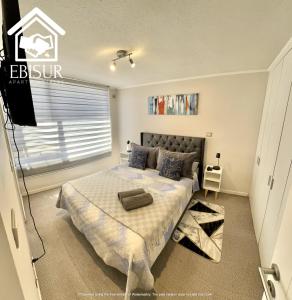 1 dormitorio con 1 cama y TV en EBISUR Apart - Hoteles MAIPU en Concepción