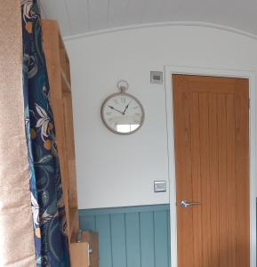 a clock on a wall next to a door at The Mad Hatter's Hut in Carlisle