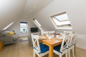 a dining room and living room with a table and chairs at Happy Days in St Ives