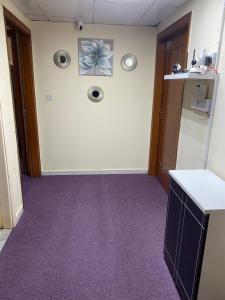 an office hallway with purple carpet and a wall at Dream valley hostel in Abu Dhabi