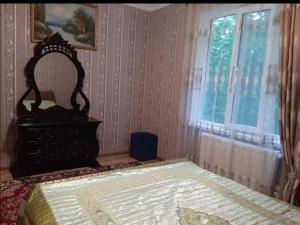 um quarto com uma cama com um espelho e uma janela em Bağ evleri, villalar em Qǝçrǝş