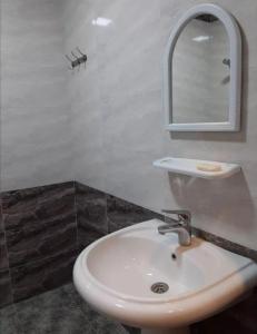 uma casa de banho com um lavatório branco e um espelho. em Bağ evleri, villalar em Qǝçrǝş