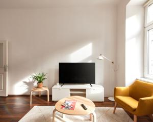 - un salon avec une télévision, une chaise et une table dans l'établissement Perfecto Apartments with Designers Touch 24H Check-in, à Vienne