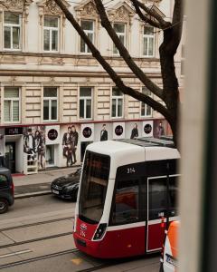 un tramway rouge et blanc dans une rue de la ville dans l'établissement Perfecto Apartments with Designers Touch 24H Check-in, à Vienne