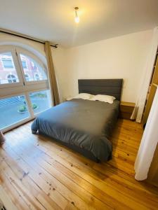 1 cama en un dormitorio con ventana grande en T3 au pied des pistes CAUTERETS, en Cauterets