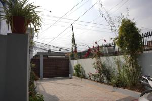 a backyard with a gate and a fence with plants at Anita's Home in Kathmandu