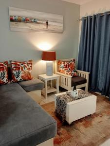 sala de estar con sofá, sillas y mesa en A Cherry Lane Self Catering and B&B, en Bloemfontein