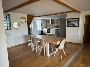 een keuken en eetkamer met een houten tafel en stoelen bij La maison du bon air in Wimereux