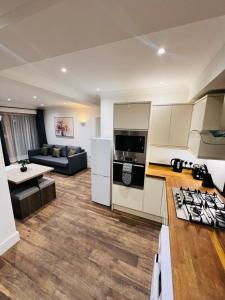 cocina y sala de estar con fogones y sofá en Luxury apartment near London centre, near train station, E1, en Londres