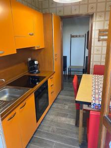 a kitchen with orange cabinets and a table and a dining room at La terrazza con le biciclette a due passi dal lago in Arona