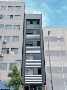 um edifício alto com uma luz de rua em frente em 【三米通天閣】602-6FB難波商圈天王寺心斎橋10min em Osaka
