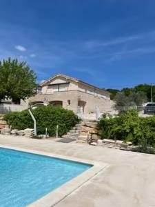 uma casa com piscina em frente a uma casa em Maëliette em Montclus