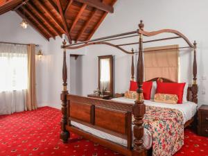 um quarto com uma cama de dossel e um tapete vermelho em Little England by Joes em Nuwara Eliya