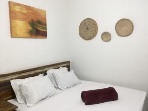 a bedroom with a bed with white sheets and pillows at Suites Mar e Lua em casa compartilhada in Ubatuba