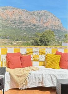 1 cama con almohadas coloridas frente a una montaña en Penthouse in Jesus Pobre, en Jesús Pobre