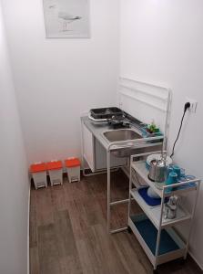 uma pequena cozinha com um lavatório e uma mesa em Brezza Marina Studios em Montesilvano