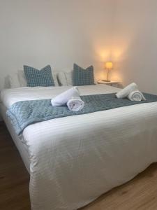 een slaapkamer met een groot wit bed en handdoeken bij DH Apartamento Turistico in Cangas de Onís