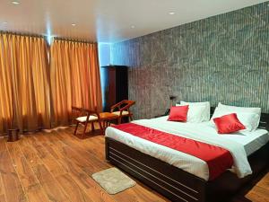 1 dormitorio con 1 cama grande con almohadas rojas en Universal Hotel, en Bongaigaon