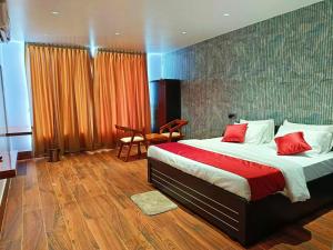 een slaapkamer met een groot bed met rode kussens bij Universal Hotel in Bongaigaon