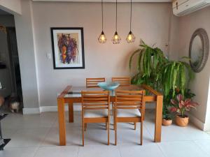 comedor con mesa de madera y sillas en Suíte Aconchegante en Belém