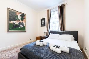 a bedroom with a bed with two towels on it at Luxury 4 bedroom flat in Sussex Gardens in London