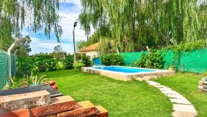 a backyard with a swimming pool in the grass at Los Sauces, casas con piscinas privadas en barrio residencial in San Carlos de Bolívar