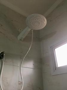 a white ceiling light in a room with a window at Suites Mar e Lua em casa compartilhada in Ubatuba +11 photos