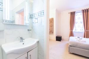 a bathroom with a sink and a mirror at Luxury 4 bedroom flat in Sussex Gardens in London