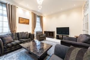 un salon avec des canapés et une télévision dans l'établissement Luxury 4 bedroom flat in Sussex Gardens, à Londres