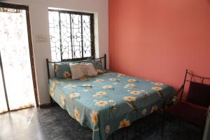 een slaapkamer met een bed met een blauw dekbed bij Dreamcatcher House & Hostel at Arambol Beach in Arambol
