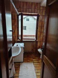 a small bathroom with a sink and a window at Ciasa de Carla in Masarè