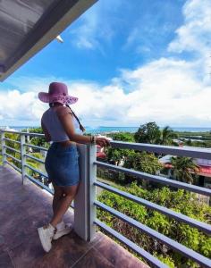 Une femme debout sur une clôture qui regarde l'océan dans l'établissement Perry Hill Best View 2, la mejor vista de la isla, à San Andrés