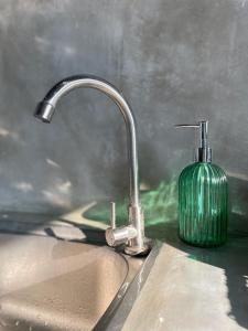 - un évier de cuisine avec un robinet et un savon vert dans l'établissement Three Creeks Matale, à Matale